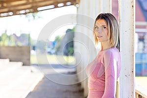 Urban Fitness Vigilance: Woman in Pink Athletic Attire Poised for Action