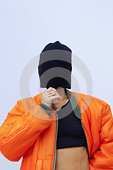 Urban Girl in fashion  street look. Trendy orange bomber jacket and stylish black beanie cap. Provocation mood. Fall winter photo