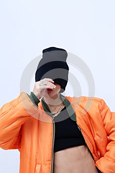 Urban Girl in fashion  street look. Trendy orange bomber jacket and stylish black beanie cap. Provocation sexy mood. Fall winter photo