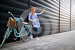 Urban girl taking selfie in city near bike