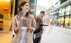 Urban happy business woman using tablet computer and working