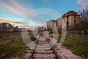 Urban Industrial landscape at dusk, in a sunset evening, in Belgrade, Serbia, with a single railway track passing in the middle