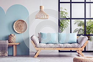 Urban jungle in bright white and blue living room interior with scandinavian futon sofa photo