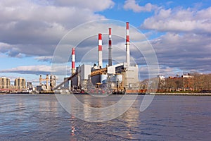 Urban landscape with electric power station on a riverbank.