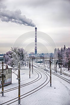urban landscape with an empty railway and a big smoking chimney