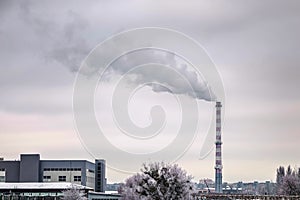 urban landscape with an empty railway and a big smoking chimney