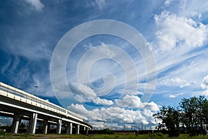 Urban landscape with highway and clouds