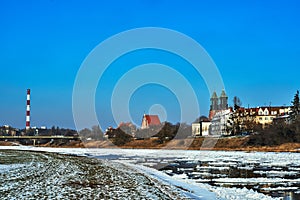 Urban landscape with river Warta and the cathedral towers in winter photo