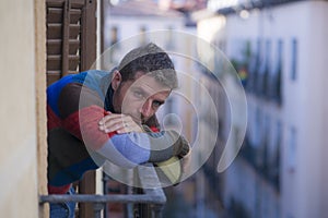 Urban lifestyle emotional portrait of 30s handsome man sad and depressed at home balcony leaning upset feeling desperate suffering