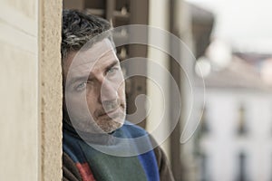 Urban lifestyle emotional portrait of 40s handsome man sad and depressed at home balcony leaning upset feeling worried suffering