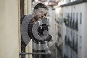 Urban lifestyle emotional portrait of 30s handsome man sad and depressed at home balcony leaning upset feeling desperate suffering