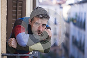 Urban lifestyle emotional portrait of 30s handsome man sad and depressed at home balcony leaning upset feeling worried suffering