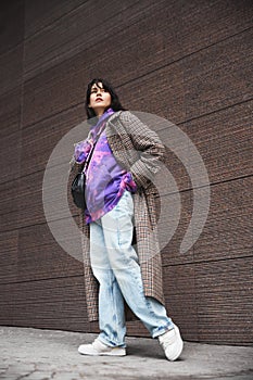 Urban lifestyle magazine. Young beautiful brunette woman wearing stylish coat, hoodie and jeans
