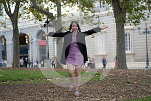 Urban lifestyle outdoors portrait of young happy and beautiful Asian Japanese woman  in sweet Autumn dress enjoying Madrid city