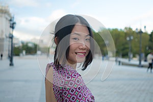 Urban lifestyle outdoors portrait of young happy and beautiful Asian Korean woman enjoying Madrid city tour relaxed and cheerful