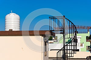 Urban Living: Rooftop View of Overhead Water Tank and Metal Staircase in Dehradun, India