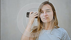 Urban loneliness, beautiful, young caucasian woman, attractively casual yet worried, standing outside on a city street, absorbing