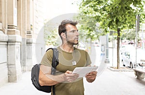Urban man with tablet computer looking away in the street