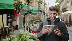 Urban man using tablet computer outside app on 5g wireless device. Casual male