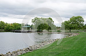 Urban Park Pond and Pier with Shelter on Cloudy Day