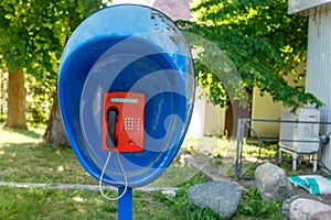 Urban payphone in the open air against the background of a Park