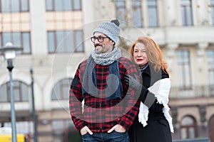 Urban people on urban background. Man and woman looking ahead. Couple waiting for city bus. Woman standing behind man`s back.