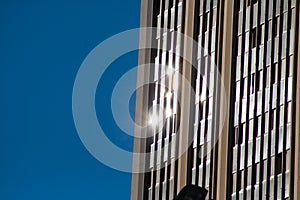 Urban reflections. Sunbeams reflected on glass of a building with blue background