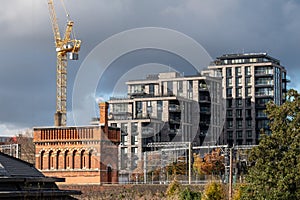 Urban regeneration of Kings Cross London UK, with new build flats and historic red brick Victorian water tower at left.