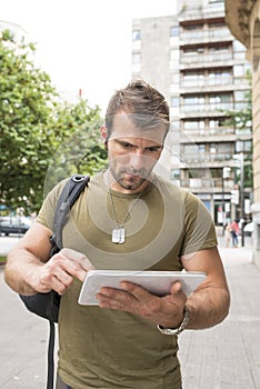 Urban serious man laptop tablet computer in the street