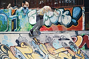 Urban skater doing tricks on the ramp in skatepark