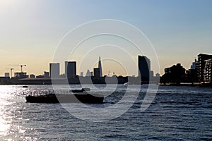 Urban skyline and river facing the sun