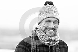 Urban smiling guy. Happy man in woolen hat and scarf. Funny man smiles to camera. Closeup of smiling urban man face