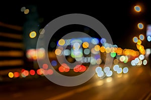 Urban street night traffic with bokeh lights. Blurred auto with bright brake lights, city street lights, speed. Abstract