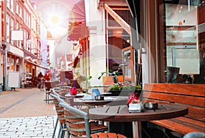 Urban street with a picturesque cafe in rays sun