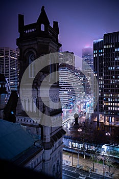 Urban street scene with illuminated buildings and a clock tower in the center