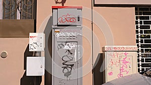 An Urban Street Scene with Unsightly Graffiti on a Utility Box.