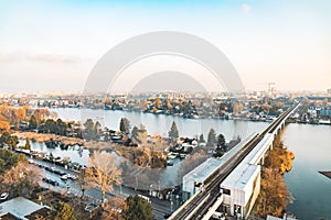 Urban top view railroad track bridge across river waterfront city district with a lot of building in morning sun rise spring time