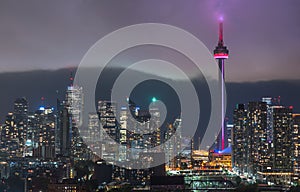 Urban Toronto illuminated skyline - glowing rain cloud quickly moves in to the downtown core.