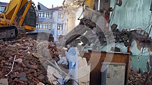 Urban transformation and demolition of old buildings, a backhoe washes the old building,