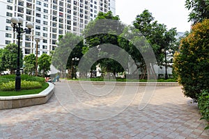 Urban walking road among green tree in modern apartment buildings in big city