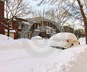 Urban winter street with cars stuck in snow