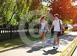 Urban young couple in love walking in sunny summer day, youth