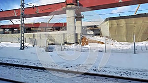 Urbanisation, a view from a train window of the construction of a multi-lane overpass running through residential and industrial