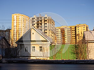 Urbanization. Old small houses against the background of large buildings