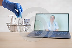 Urchase of medicines using the computer application for home delivery. Pharmacist on laptop screen. A hand in a rubber