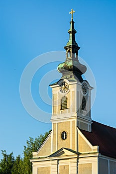 Urfahr Parish church in Linz upper Austria, view of bell tower, clock, golden sunlight, blues sky