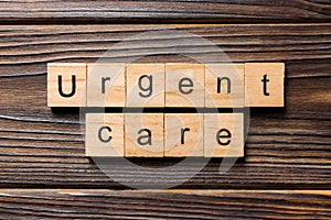 Urgent care word written on wood block. Urgent care text on wooden table for your desing, concept