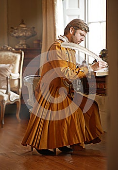 An urgent letter to the king. an aristocratic man at his writing table.