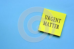 Urgent matter text on yellow sticky note