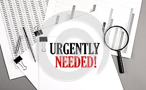 URGENTLY NEEDE text on paper on chart background